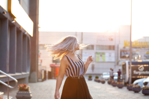 romantic blonde model with fluttering hair posing with evening light space text